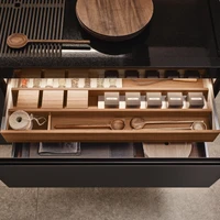 The polished Nero Assoluto granite worktops in this Arclinea Principia Convivium fitted kitchen feature a recessed workspace, holding a sliding grate in place