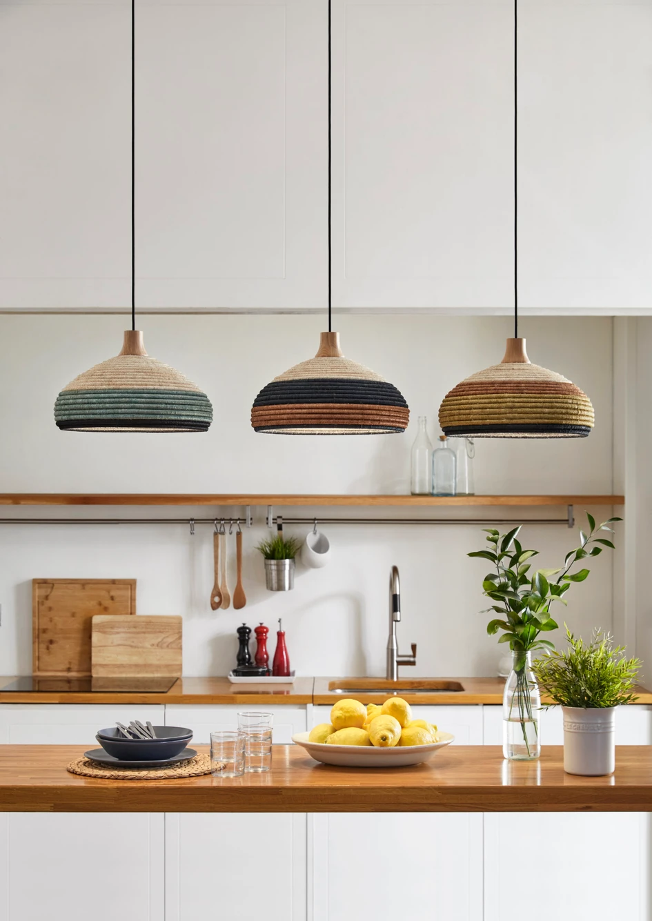 Die industrielle Inspiration der 1950er Jahre für die Form von Jette Scheibs Grass-Design ist in der Form der Pendelleuchte sichtbar. Die Wärme kommt vom natürlichen Abaca und Raffia, die auf den Philippinen handgewebt werden