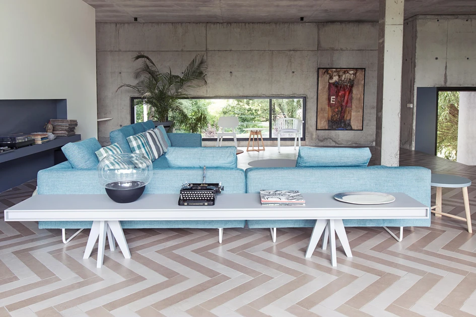 U-shaped sectional layouts like Brühl’s amber sofa can line three walls (top), but when used in central areas, like this Lost sofa from Moya (bottom), they need accompanying furniture