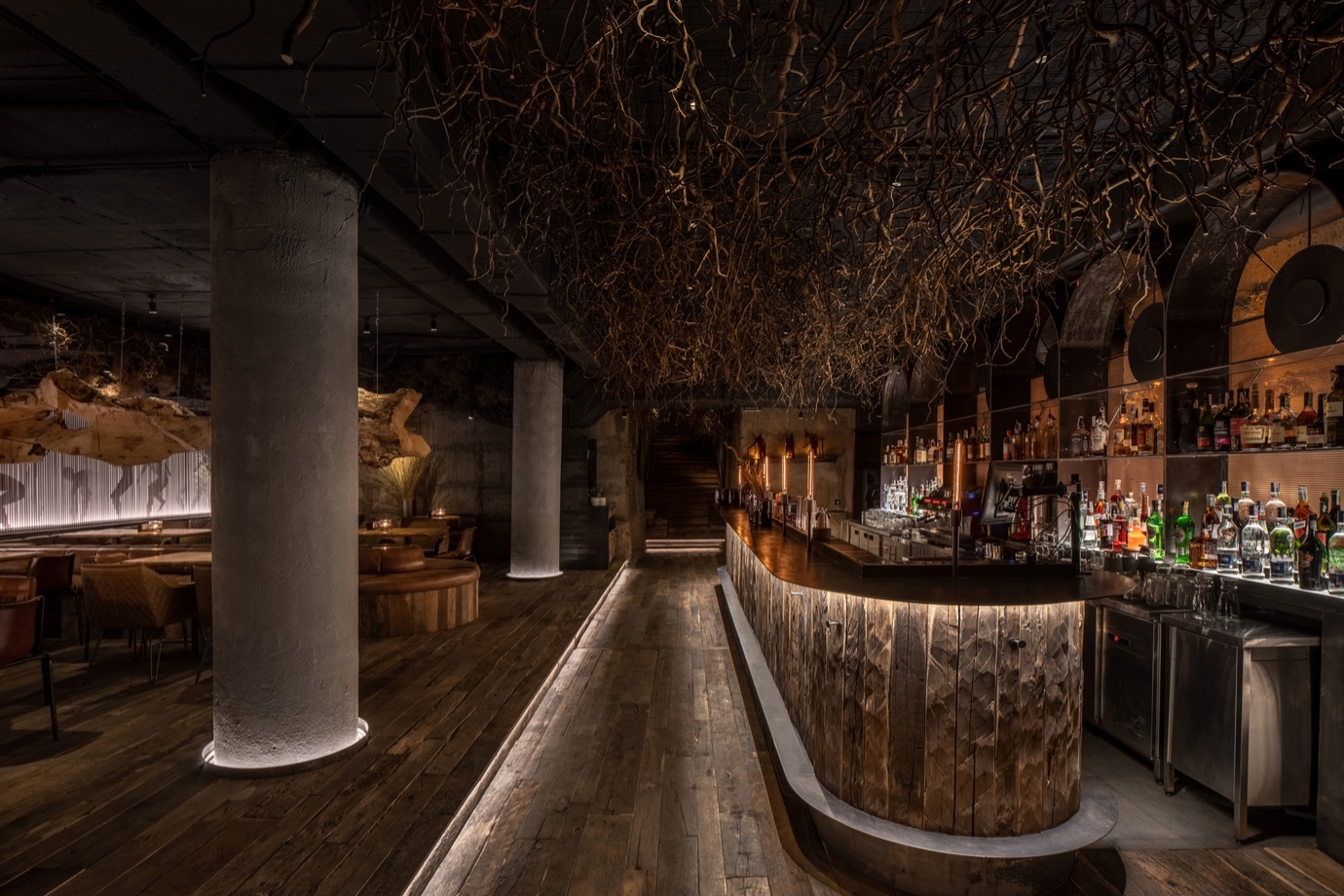 The dark environment of the Deep Bar combines with natural, organic surfaces and materials to transport visitors to another point in time where life takes place underground. Photo: Andriy Bezuglov