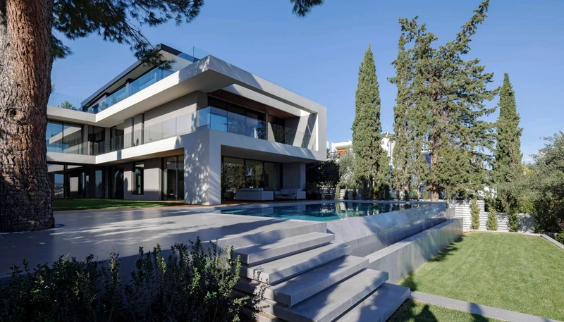 Wooden and dark stone surfaces spread across Villa Filothei's garden, creating luxurious outdoor areas