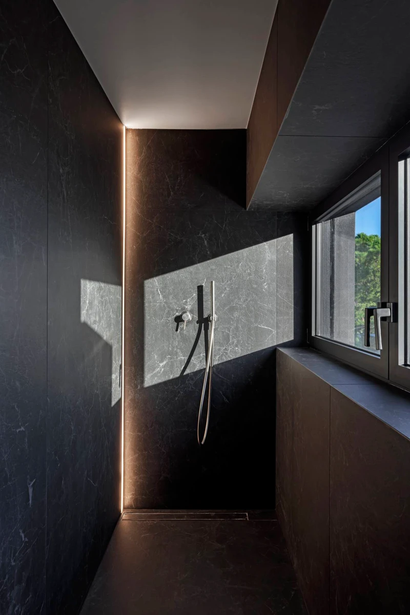Twelve Concept's shower spaces feature natural stone finishes in dark hues combined with perfectly planned contemporary lighting