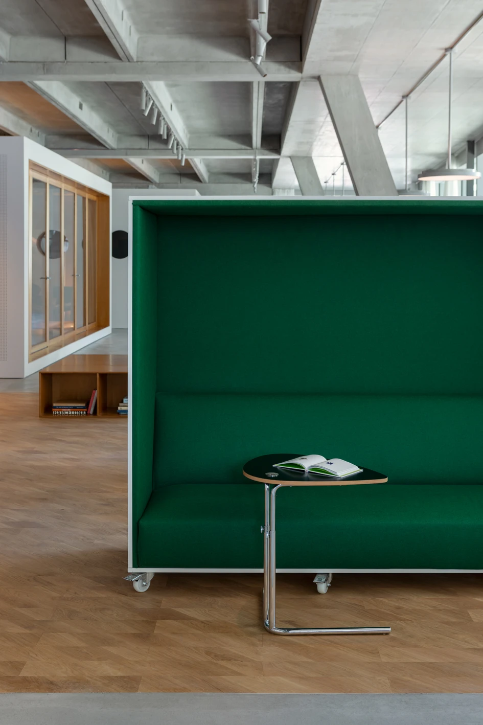 Der natürliche Holzboden hebt den zentralen Bereich optisch hervor und wird durch Möbel ergänzt, die sowohl Kommunikation als auch Entspannung fördern. Foto: Ivan Avdieienko