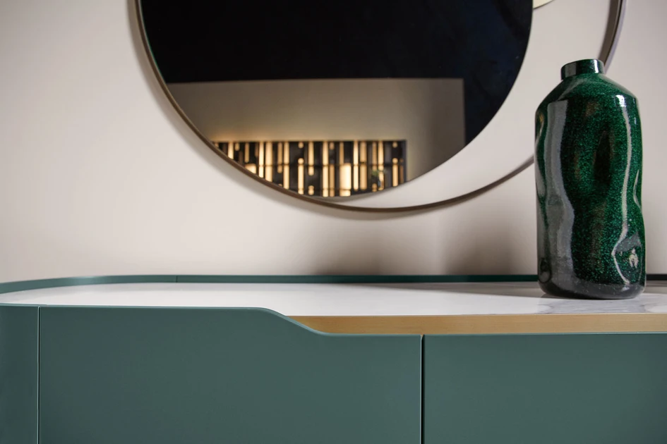 Carefully crafted curved wooden panels meet seamless joints, while slim metal inlays at the doors mark precision in restraint