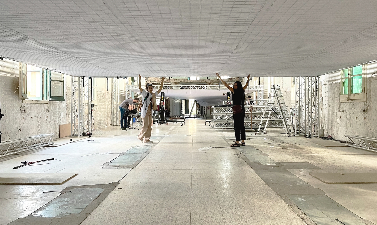 Stretching white tarpaulin across a temporary frame in the Nuestra Señora Del Carme allowed the architects to cover the space in branded orange light for an LR3 fashion show. Photo: Pol Viladoms (top)