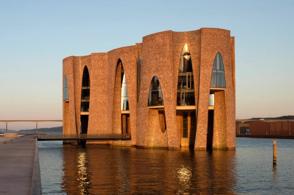 Das Fjordenhus, Teil eines Projekts zur Revitalisierung des Hafens von Vejle in Dänemark, scheint wie eine natürlich geformte Koralle aus dem Wasser zu ragen. Foto: Anders Sune Berg