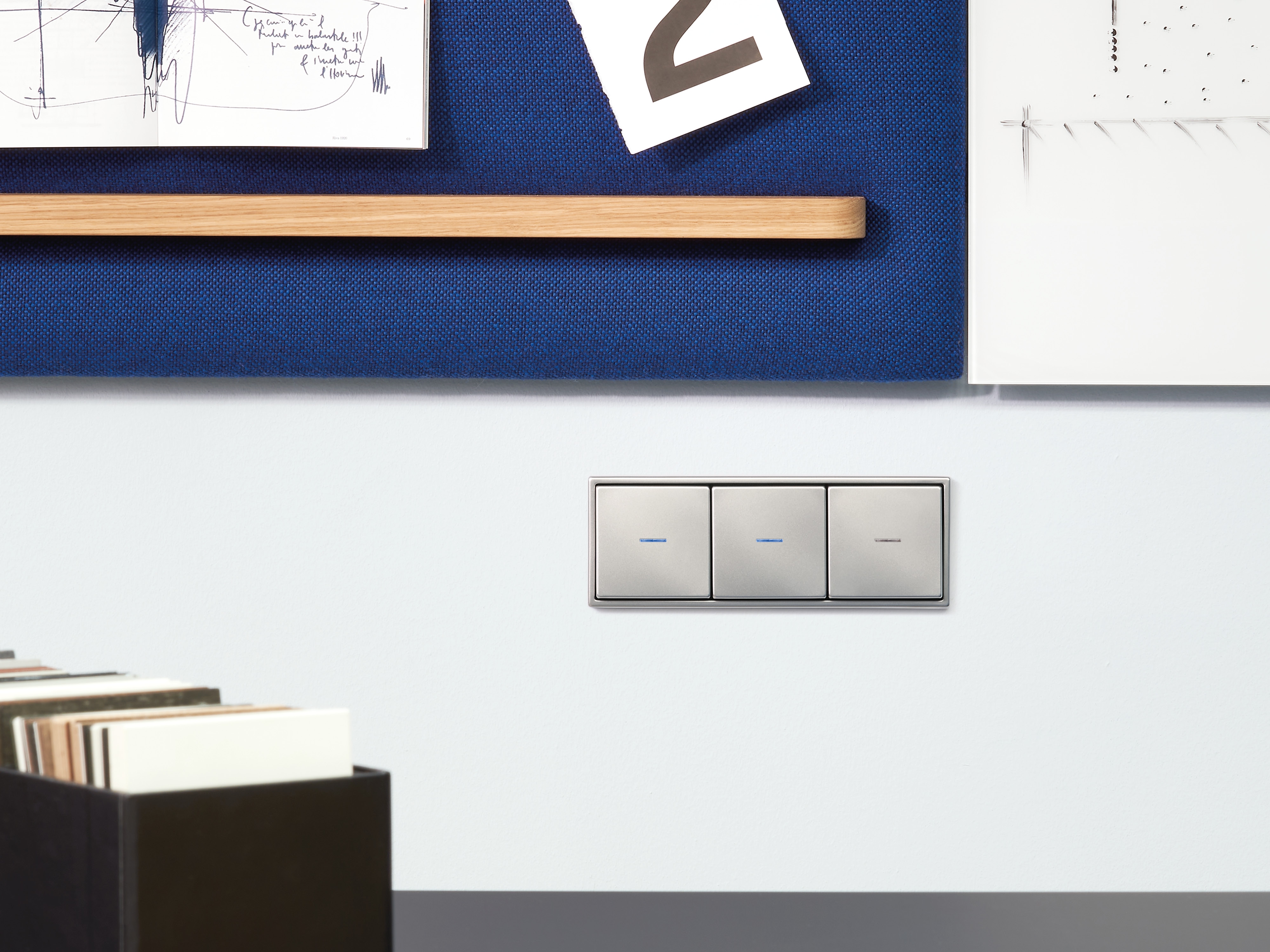JUNG HOME sockets (top) can be switched via pushbuttons, a smartphone app or the control point on the socket itself. The switches (below) are available wired or wireless, and can be used to switch or dim lights, or operate blinds