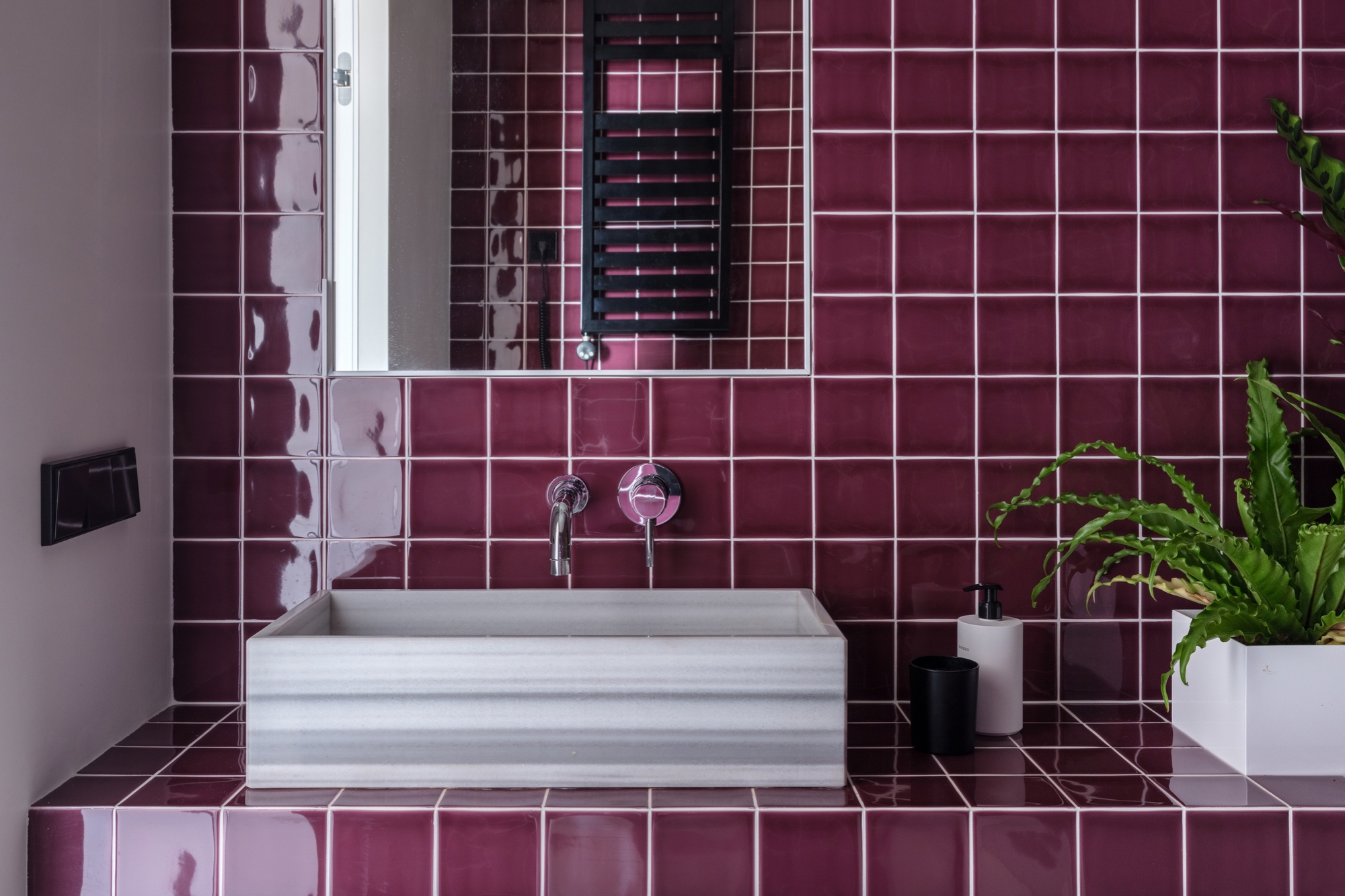 Weisse Fugen bilden einen sicheren Kontrast zu jeder Fliesenfarbe, wirken aber besonders gut, wenn sie mit kräftigen Tönen wie den pflaumen- oder auberginefarbenen Fliesen der Wohnung Puce kombiniert werden. Foto: Mikhail Loskutov