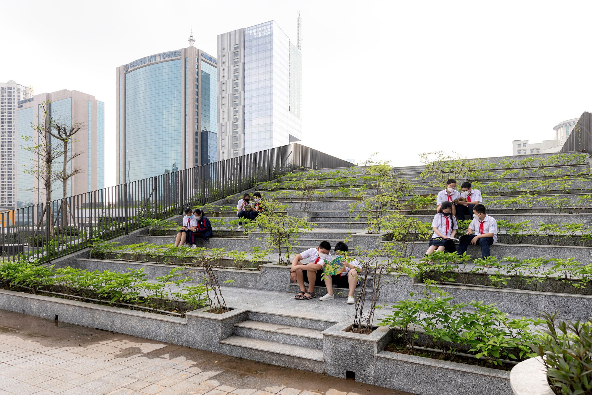 Either in a shaded and ventilated green corridor (top), over connecting bridges (middle) or on rooftop garden steps (bottom), Tran Duy Hung students spend a lot of time outdoors. Photos: Chimon Studio