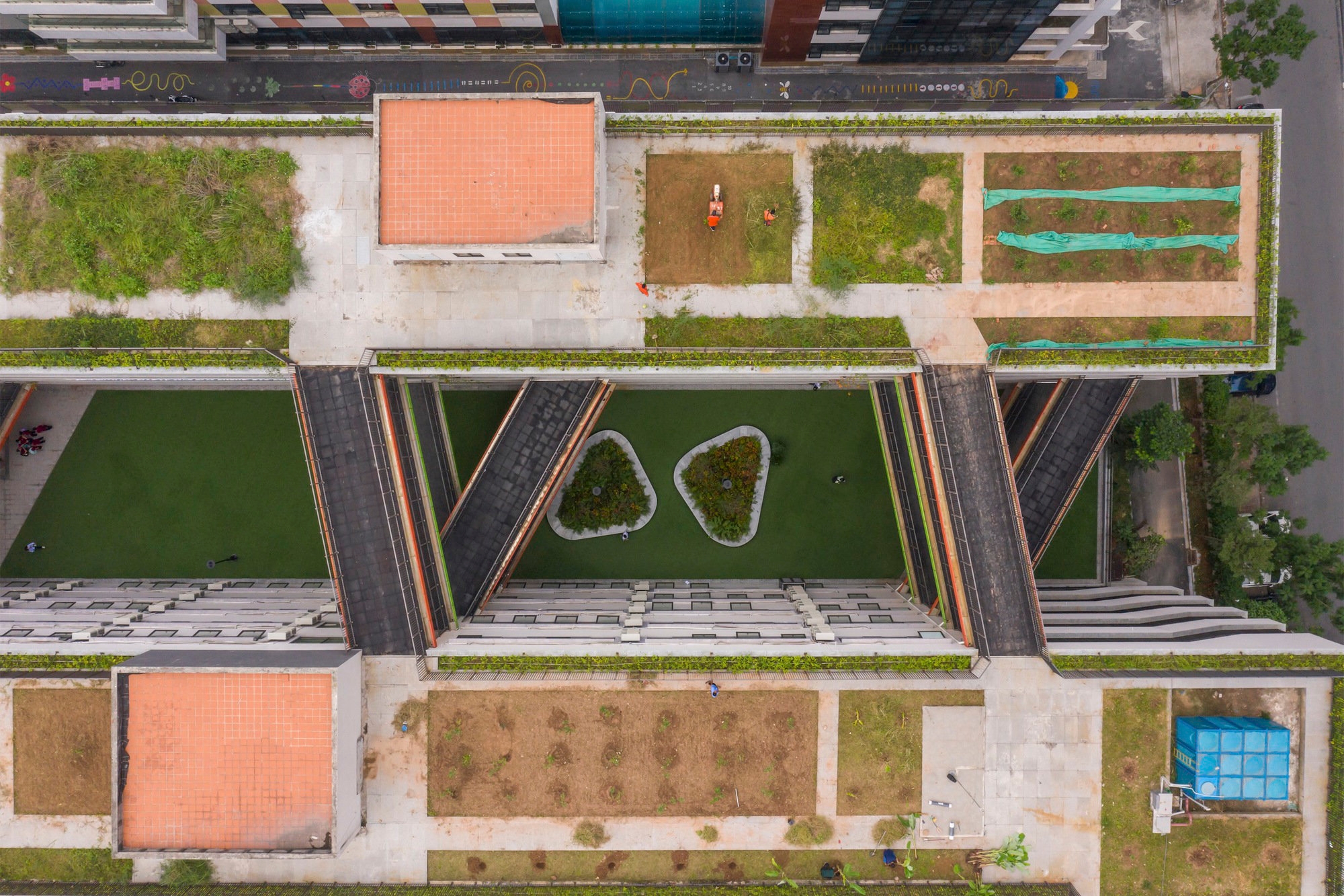 Hanoi’s Tran Duy Hung School protects its ground-level green space from noise and humidity, while providing additional green and botanical learning spaces above on its rooftops. Photo: Chimnon Studio