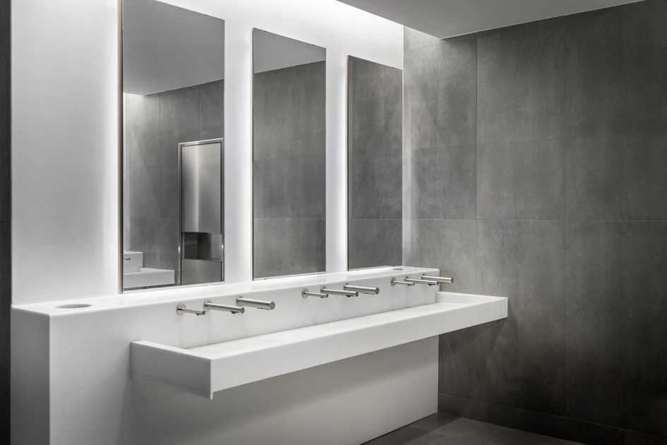 The modern and minimalist bathrooms designed by Luis Vidal Architects for the DFW Terminal D South feature custom Monolith C Series basins with an IOT network connecting the soap dispensers to alert staff when levels are falling