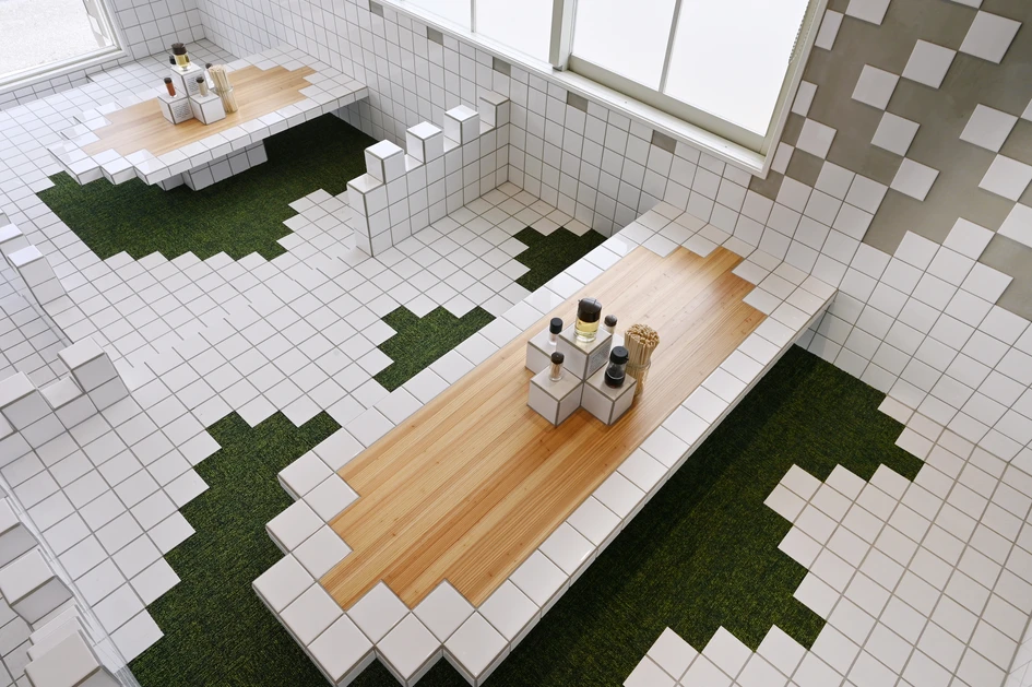 Ceramic white tiles bring suitable pixellated surfaces to the video-game-themed Kaishin No Ichigeki noodle bar, while green carpet tiles encourage diners to sit or kneel in comfort. Photos: Yoshiaki Ida