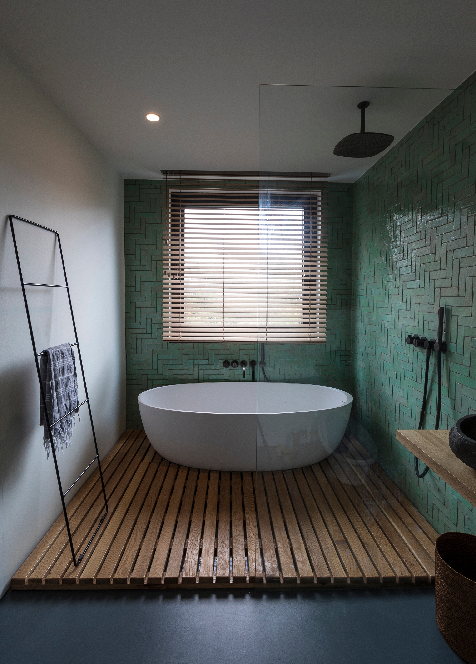 The straight-lined herringbone pattern of the Frans Hasstraat bathroom is all the decoration the bath and shower walls need. Photo: Luuk Smits