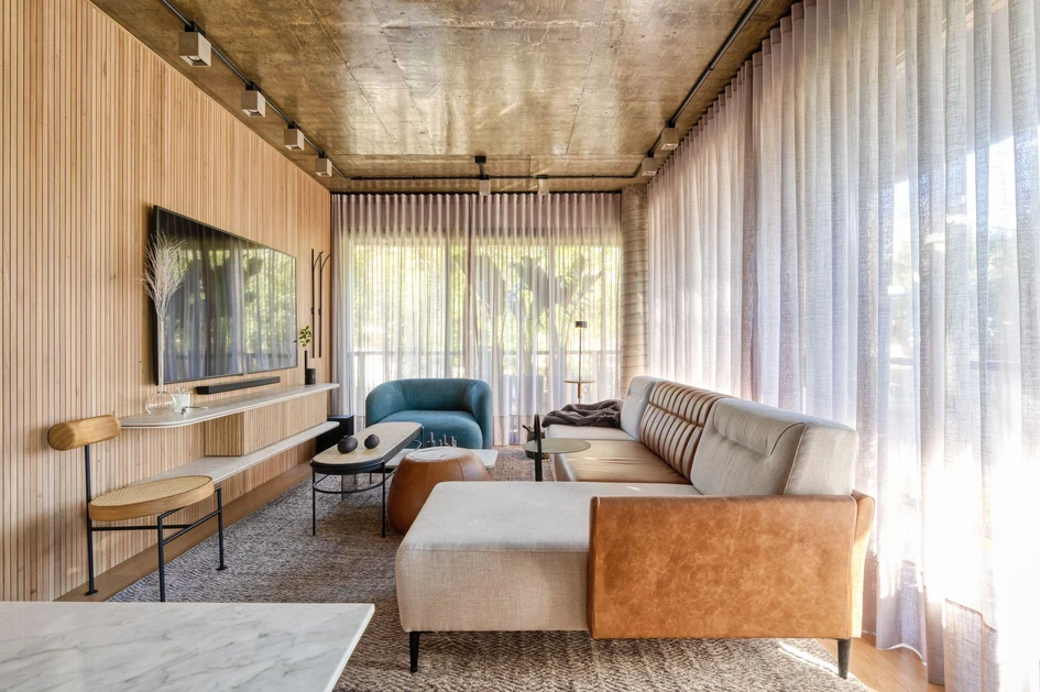 Light translucent full-length curtains draw texture and depth across the edges of the Loft Chartier’s living space by Studio Colnaghi Arquitetura. Photo: Vinicius Ferzeli