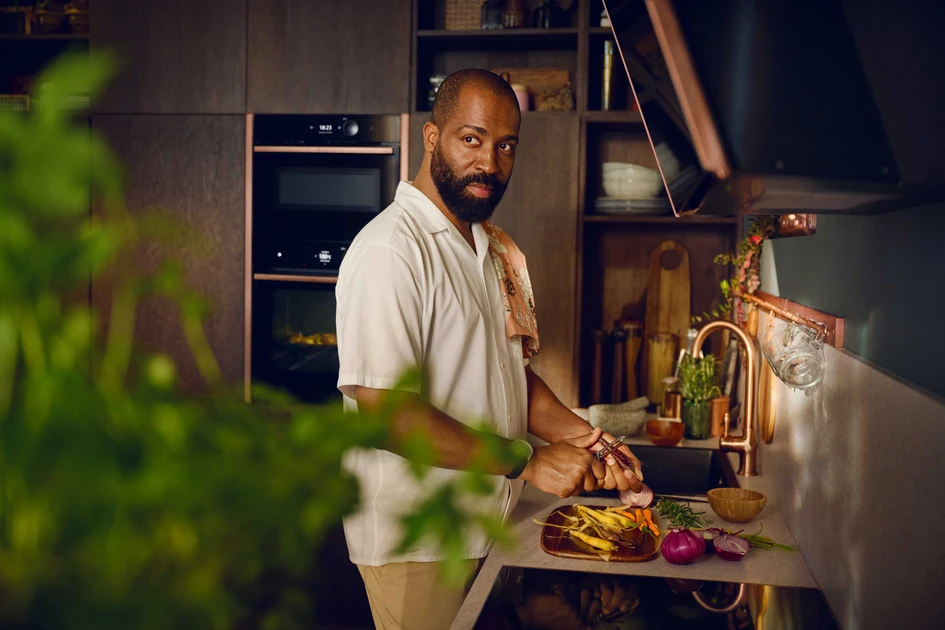 The interior stylist Chris Glass has chosen Brushed Bronze to trim his oven, hob and hood, making the appliances themselves a design statement