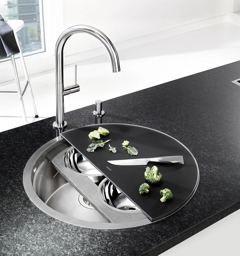Franke Home Solutions’ Urban Sink (top, middle) fits in more bowl by moving the tap fixture to one side, while Blanco has added accessory trays to extend the usability of its circular Ronis sink (bottom)