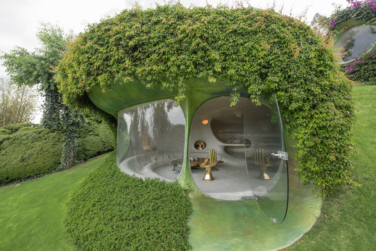 The organic-shaped bubble-formed windows of the underground Organic House (top, middle), with a frameless glass door leading out to the rear (bottom). Photos courtesy of Javier Senosiain