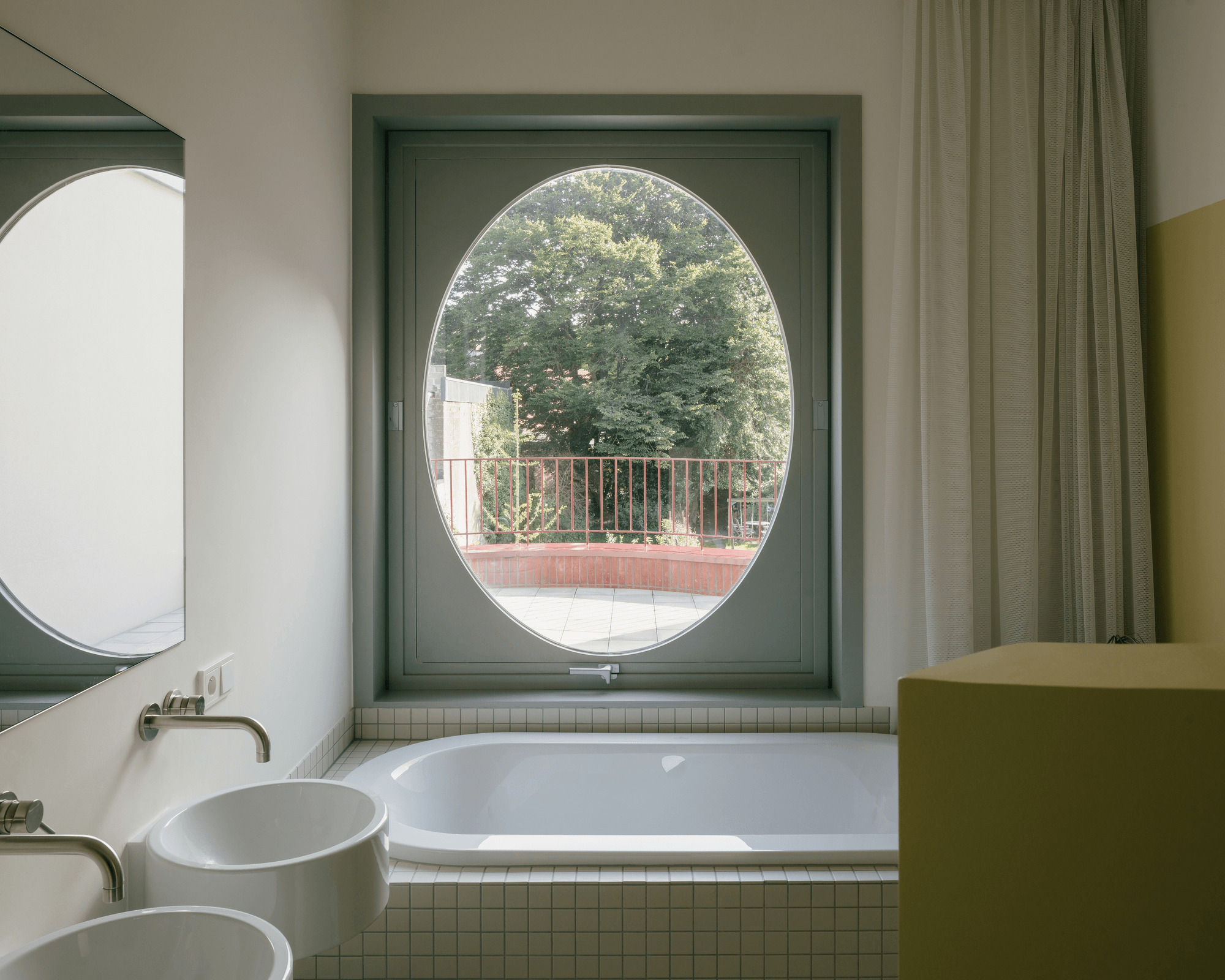 Windsor Castle’s large circular window (top, middle) and the oval-shaped window framing a bathtub view at Sint Benedictus House (bottom). Photos: Field Carr (top, middle), Stijn Bollaert (bottom)