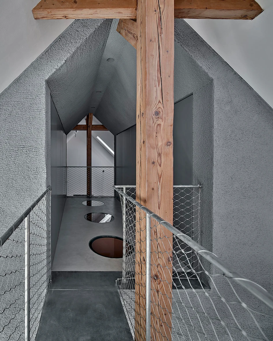 The monochrome Attic Reconstruction in Gliwice, Poland, provides colour through a playful shade of reddish brown on all sides of its central bathroom. Reflections caused by circular skylights add further visual intrigue and fun. Photos: Jakub Certowicz