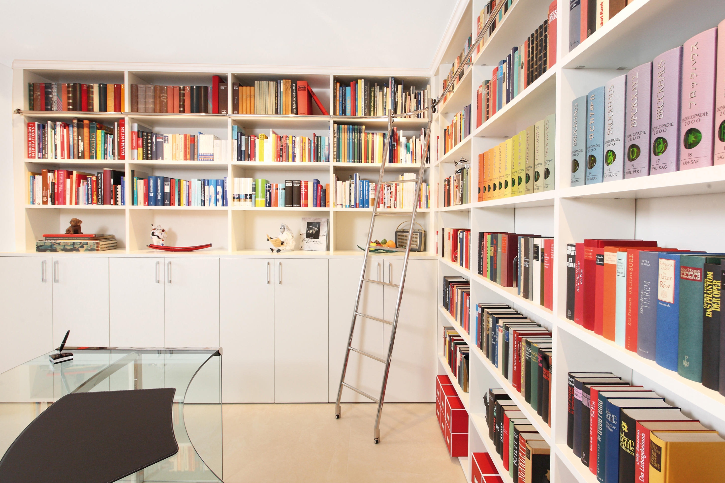 Set on wheels, track ladders like MWE Edelstahlmanufaktur’s Klassik Sliding ladder system (top), and curved track ladders like the Vario system (bottom), glide into place