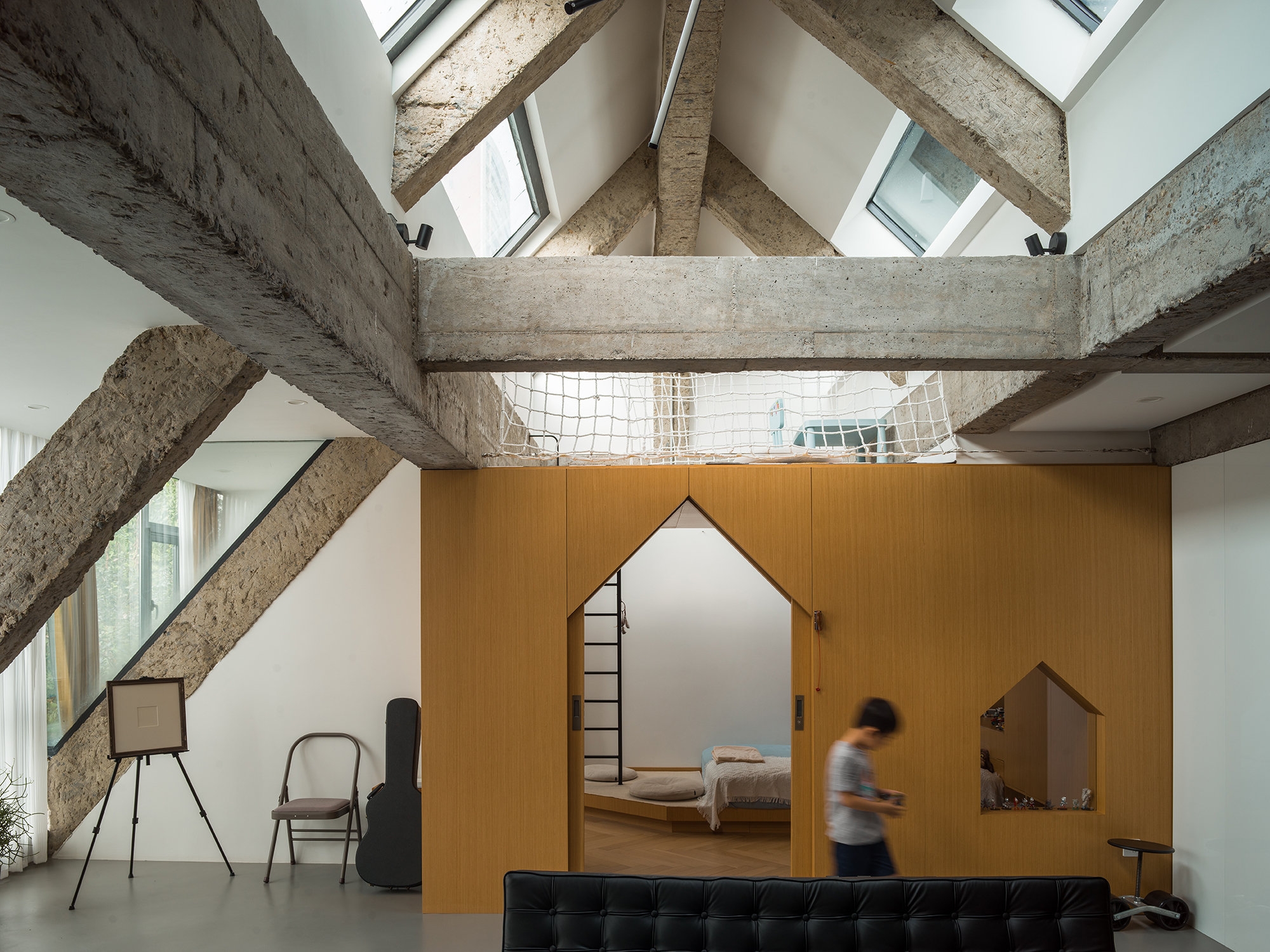 Connecting a children’s playroom with a private mezzanine level, the interior ladder at the Liang House is made safe with safety bars to hold onto near the top. Photos: Haiting Sun