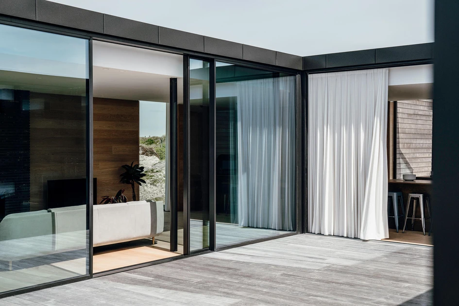 Solarlux’s bi-folding Highline doors (top, middle) and cero III sliding doors allow the kitchen, bedroom and living space of this Danish beach house to remain open to the sea any time of day or night. Photos: Malik Pahlmann