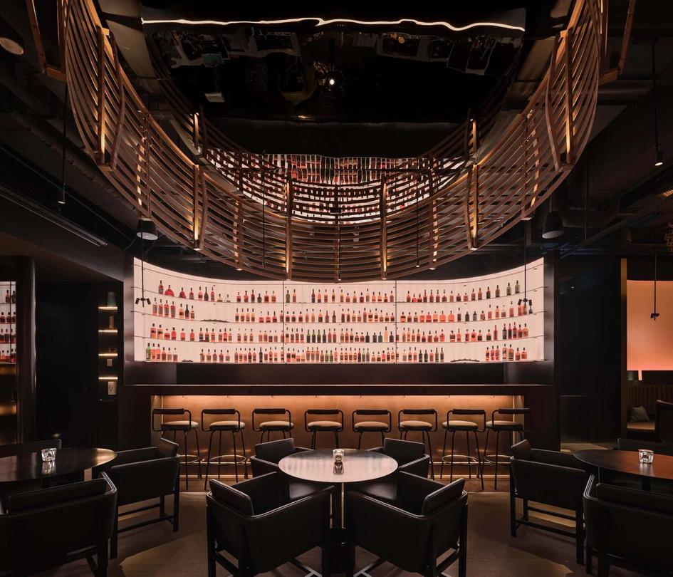 The near-blackout Laizhou Bar, barely lit by diffused panels and large ‘nest’ lighting features made from remnants of used whisky barrels, enhances the relaxation provided by the drink. Photos: Wen Studio