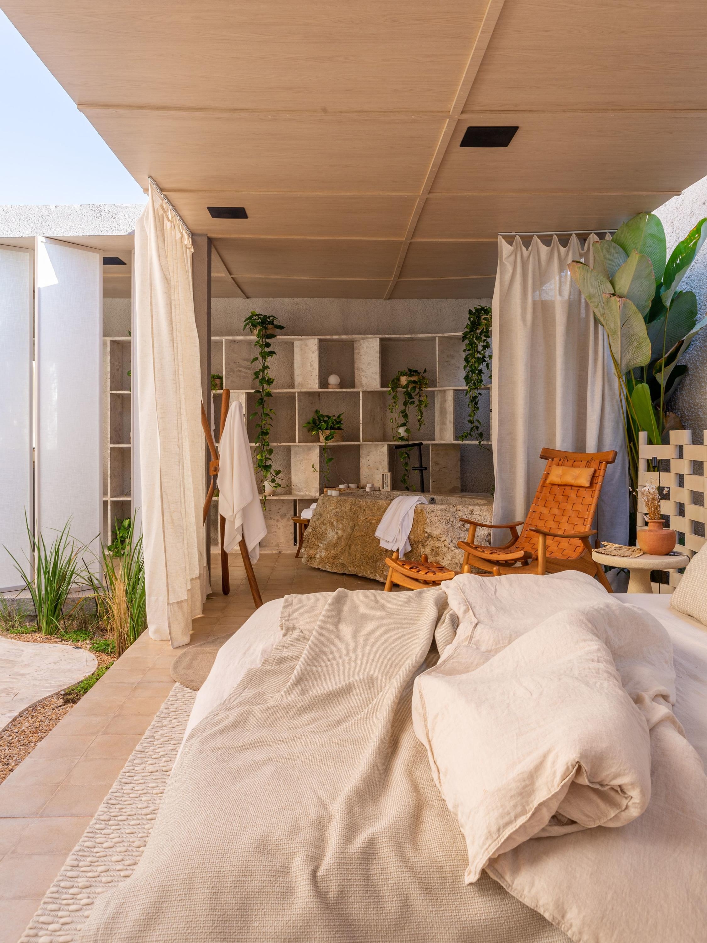The central outdoor space at Oásis Ventú (top) connects all interior spaces with a pathway of local bahia marble. Bathroom and bedroom seamlessly flow into one another and highlight vegetation and organic materials. Photos: Lucas Panobianco
