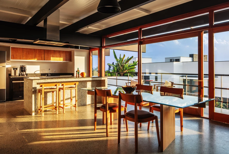 At Suki House in São José Dos Campos, the home’s industrial aesthetics are balanced out with wooden accents throughout and large sliding glass doors that enable indoor-outdoor living, including off the kitchen (bottom). Photos: Nelson Kon