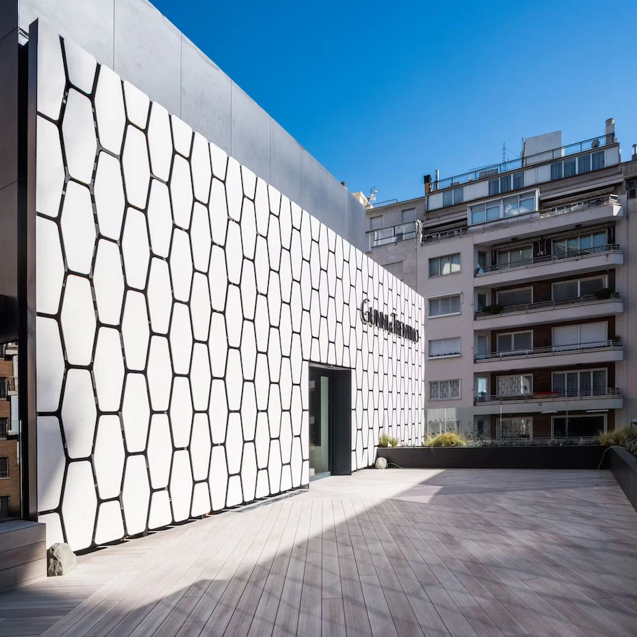 The Madrid showroom of interior design brand Gunni and Trentino has a creative facade made from tessellated Dekton slabs arranged in a honeycomb pattern