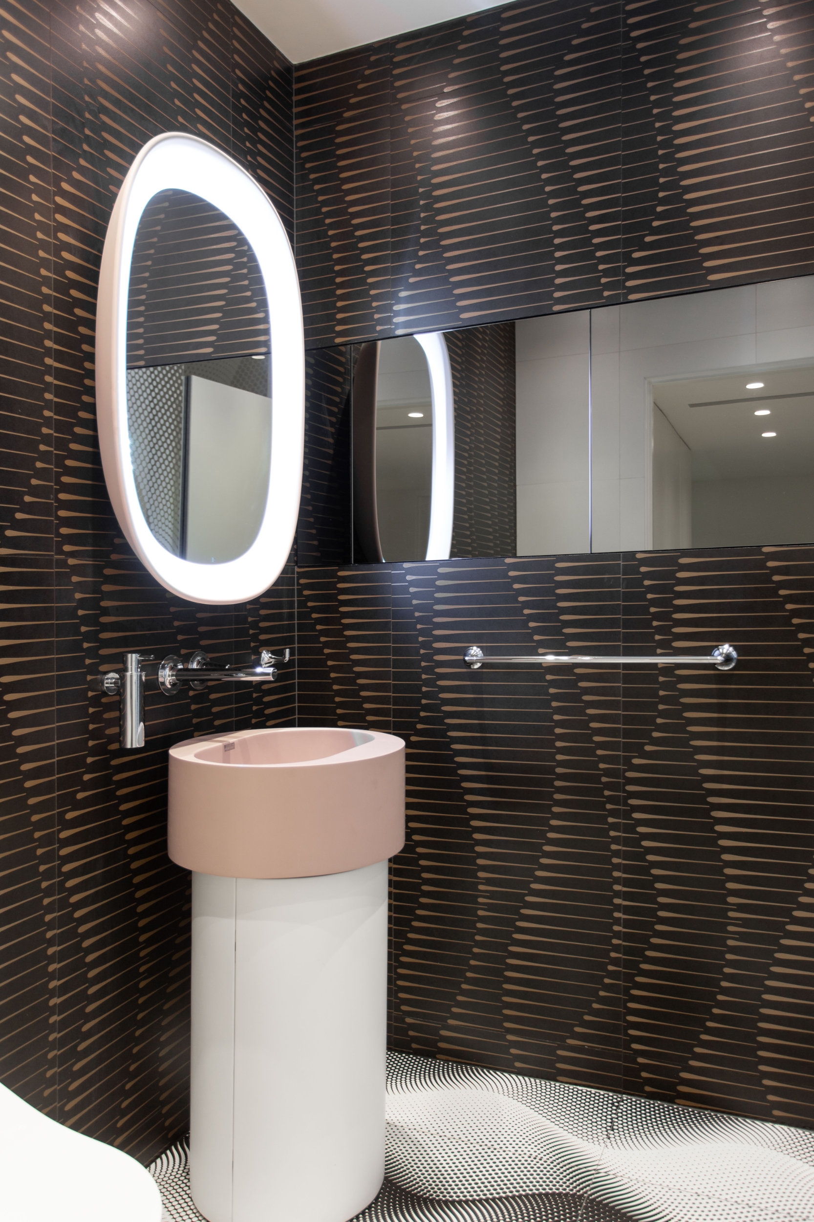 The organically shaped objects, the decorative wall and floor surfaces together with the mirrors, add playfulness – almost to the point of optical illusion – to an otherwise simple square bathroom space 
