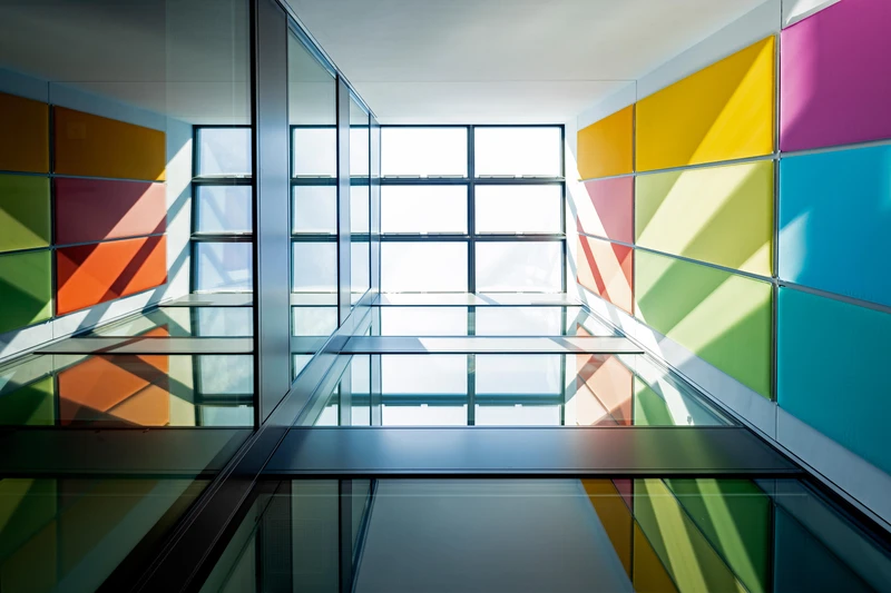 Brightly-coloured panels set in the Guest House's atrium fill each floor with spectacular colours. Photo: Andreas Wiese