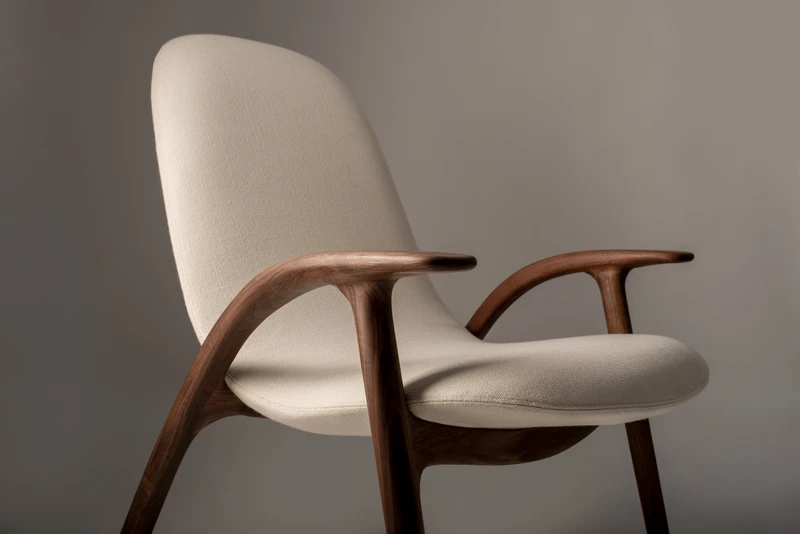 The distinctive armrest of the Alpha lounge chair, designed by Stefano Bigi, seamlessly extends from the back leg, crafted through the process of steaming and bending wood