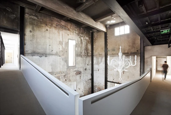 The hotel’s interiors confidently combine the peeling plaster and exposed brickwork of the original building with smoothly finished contemporary details; architecture: NHDRO, photo: © Pedro Pegenaute