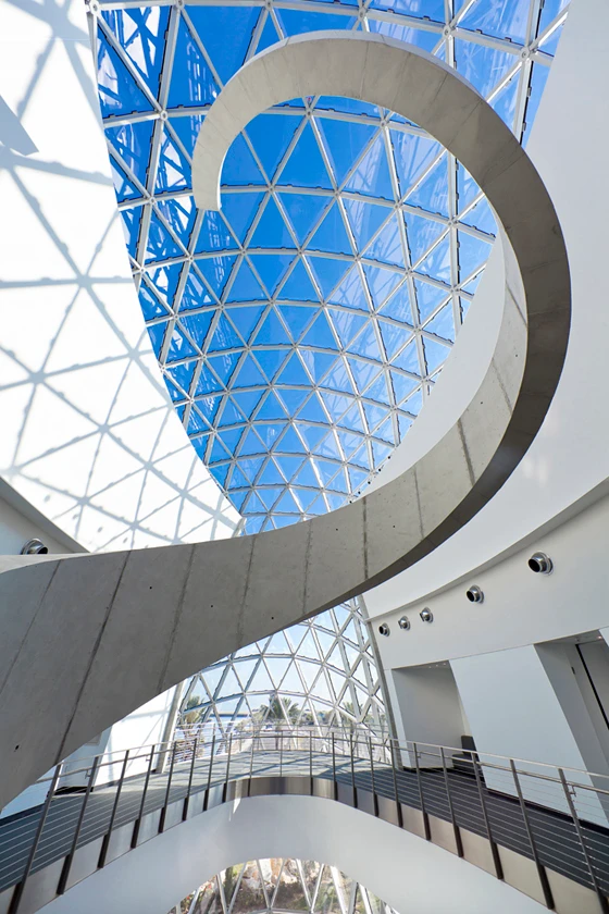 The poured concrete staircase carries visitors from the ground level entrance to the galleries on the third floor; photo © HOK/Moris Moreno