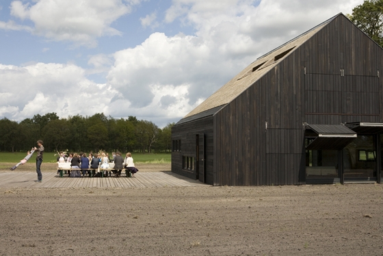 With its low eaves and wooden shutters closed, the building almost disappears into the landscape; photo Lard Buurman