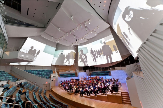 Frank Gehry's New World Center in Miami Beach, Florida, features an 80-foot-high glass curtain wall and giant LED screen on the exterior, while inside the auditorium sail-like acoustic-panels-cum-projection-screens animate the space; photos Claudia Uribe