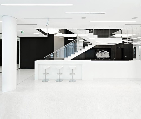 The lighting installation follows the central staircase, uniting the different levels within the space.