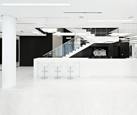 The lighting installation follows the central staircase, uniting the different levels within the space.