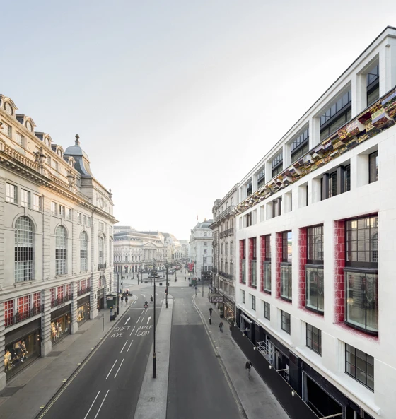The white faience facade fronting One Eagle Place, in London’s Piccadilly, is adorned with a jazzy ceramic cornice by artist Richard Deacon and red window reveals; photos Dirk Lindner