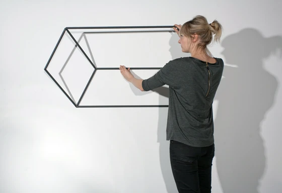 Nur scheibar 2-D: Die Quaderformen der deutschen Designerin Tina Schmid ragen aus der Wand hinaus, um höchst originelle 3-D-Kleiderstangen zu formen