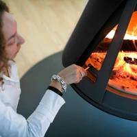 The 'Pharos Interior' stove, suspending from the ceiling, functions beyond its utilitarian purpose as an impactful interior-architectural element