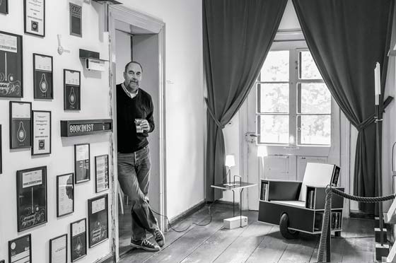 Geschäftssinn trifft auf Humor: Nils Holger Moormann mit mobilem Lesesessel «Bookinist» im Aschauer Büro