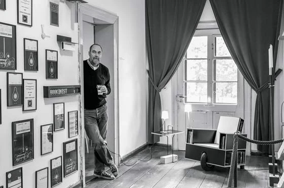 Geschäftssinn trifft auf Humor: Nils Holger Moormann mit mobilem Lesesessel «Bookinist» im Aschauer Büro