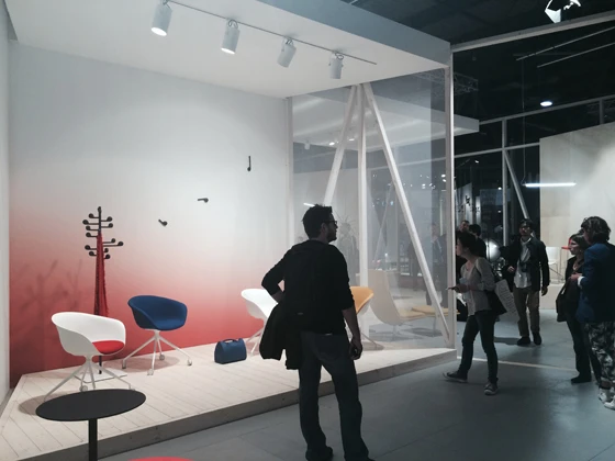 A central, boulevard-like circulatory axis at Arper's stand in Milan is attended by a number of carefully considered product stagings leading off it