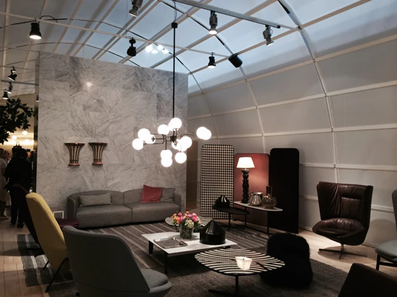 Carlo Colombo's hangar-like exhibition space for Arflex at this year's Milan Furniture Fair, internally divided with hanging screens and a marble wall