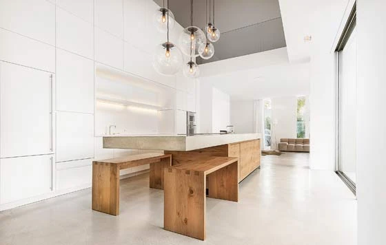 The concrete and oak kitchen island harmonises with the camouflaged two-storey wall unit