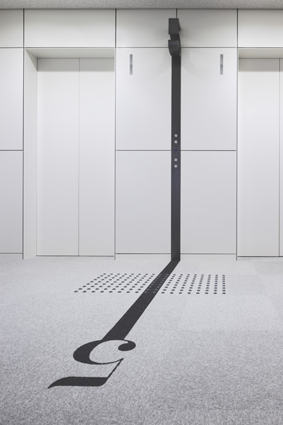 Office building in Naniwa-ku, Osaka, Japan, featuring strong typographical elements that flow seamlessly from architectural features to graphics on the floor