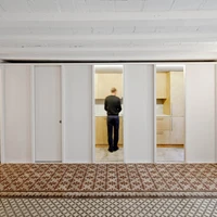 Renovated apartment in Barcelona, featuring polished mosaic floors that reveal the previous spaces within the original layout of the building