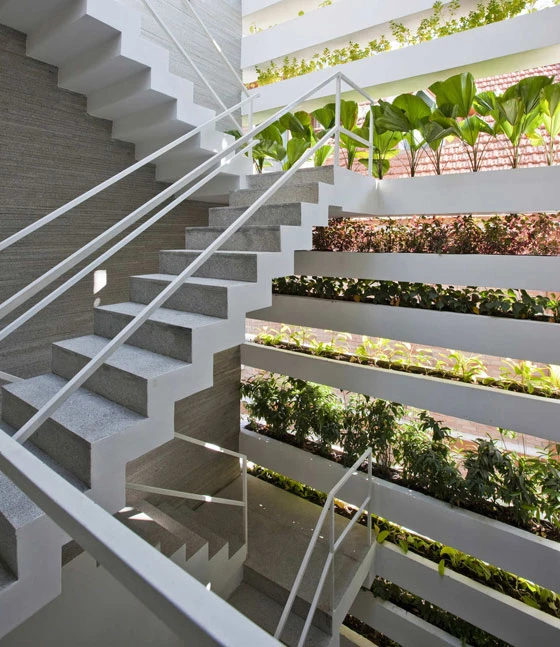 The open staircase of the detached house by Vo Trong Nghia forms an atrium that connects all storeys and functions as a filter between the interior and exterior space. It additionally allows warm air to escape upwards as in a chimney; photo: Hiroyuki Oki